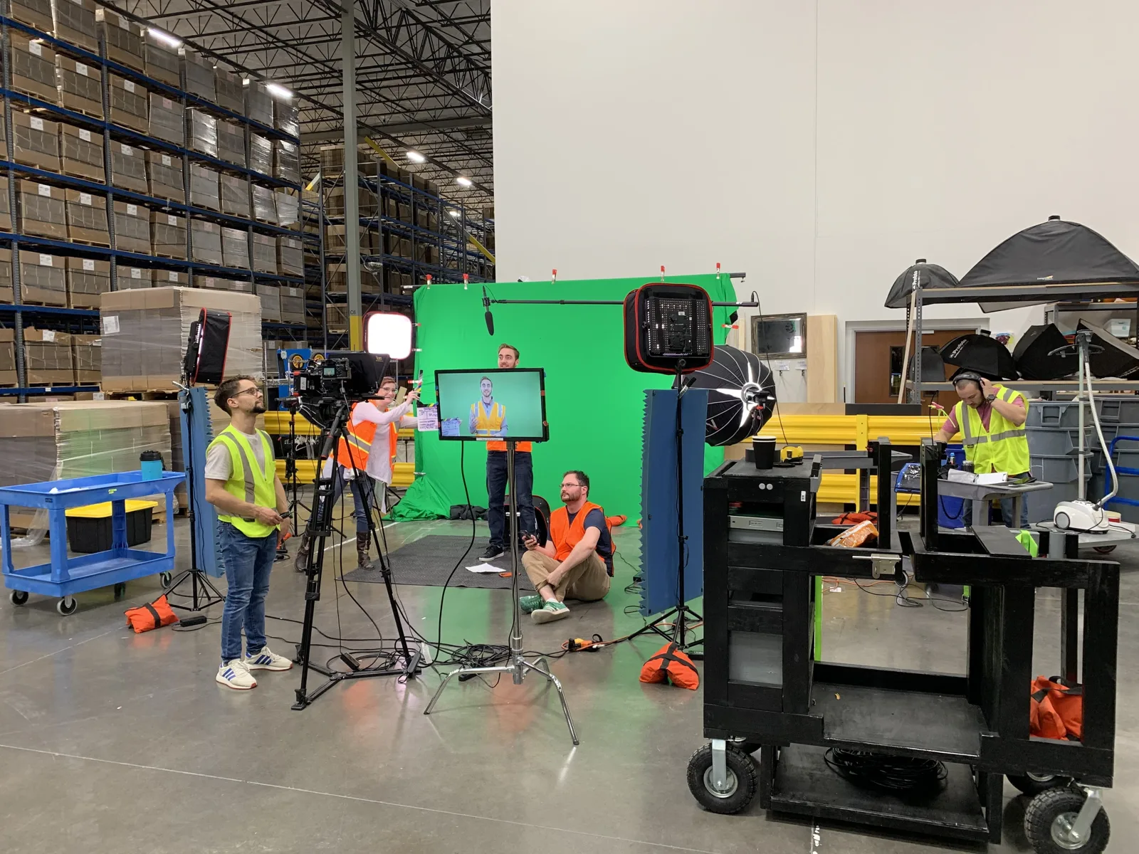 Green screen and lighting rigged inside a Chewy fulfillment warehouse for a training video shoot